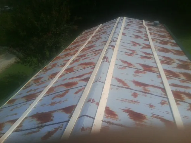 Rusted metal roof panels with new wood purlins before replacement — Storm Damage Roof Repair in Iva by Roofing Brothers