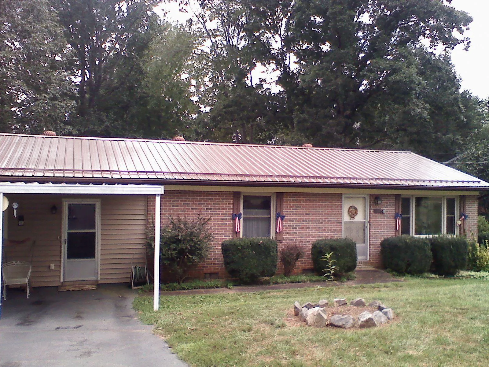 Bronze metal roof and carport on a brick ranch home — Roof Repair work by our crew in Iva